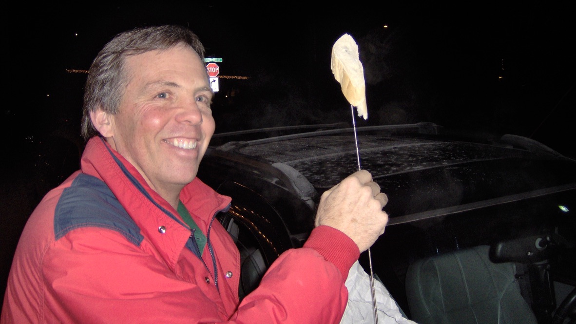 A smiling bunner in a red jacket holding a bun-topped antenna.